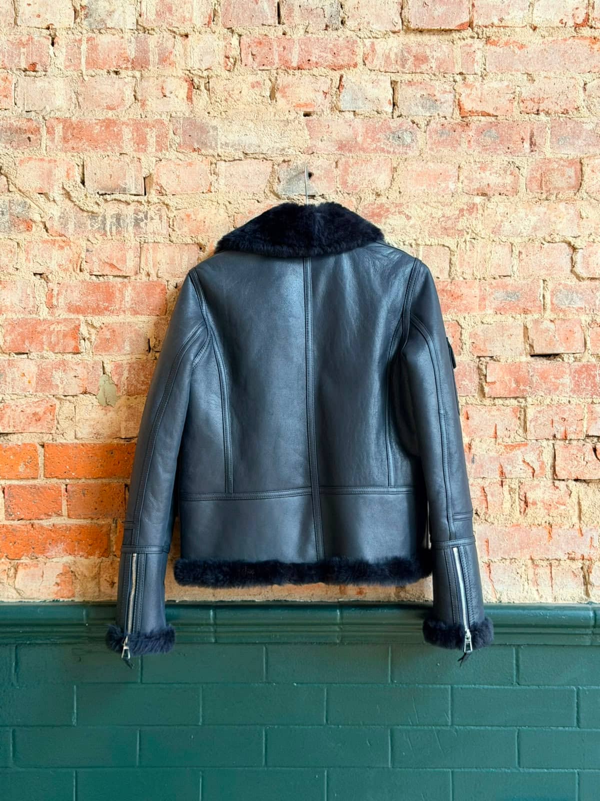 Hampstead Travel Pouch — side profile showing shearling collar and leather grain